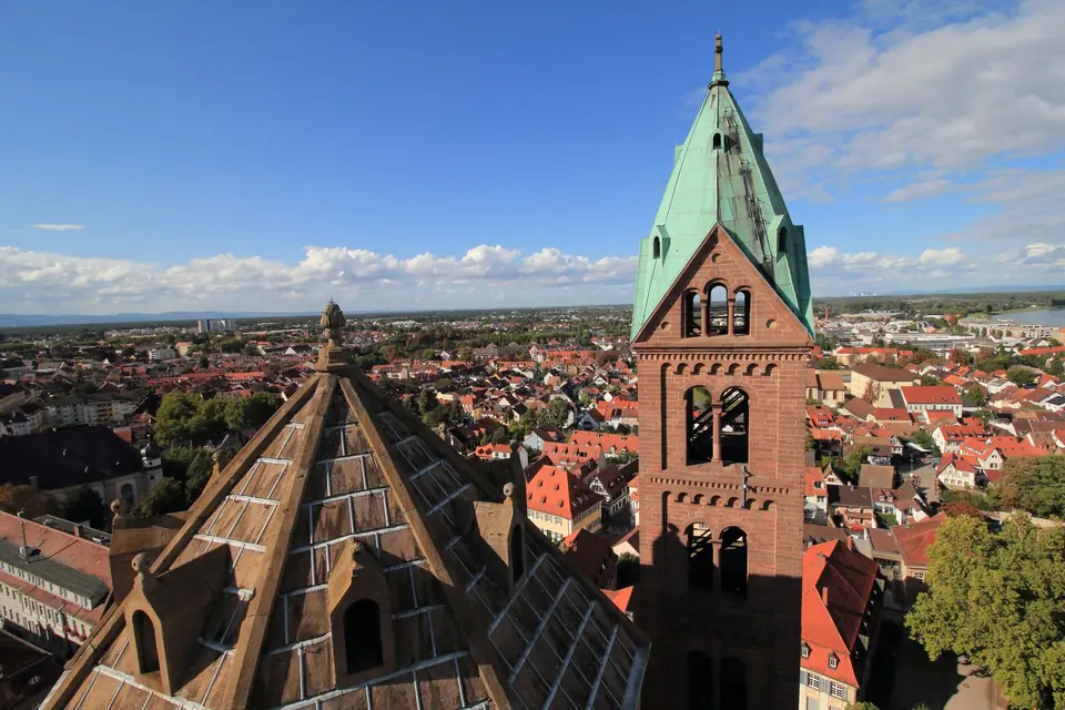 Luftaufnahme des ikonischen Turms des Speyerer Doms mit Blick auf die Stadtdächer und die Landschaft in Deutschland.